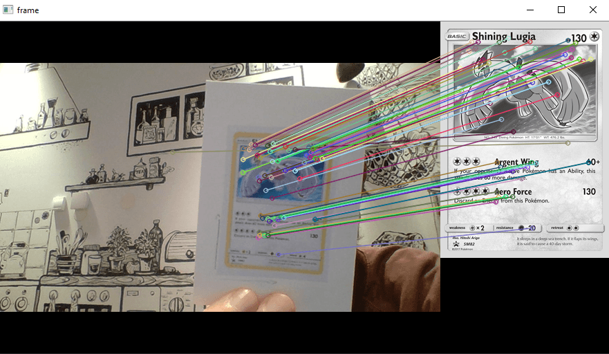 Left is a printed out card and right a reference image, features of the two are connected by colored lines..