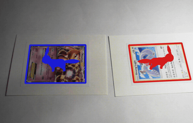 Two cards oppose each other. Outlines highlight the detected card, one in blue, one in red.