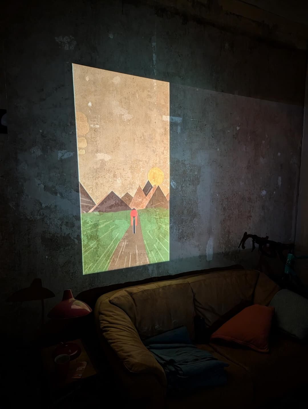 Wall with an image of a cyclist in a landscape projected onto.