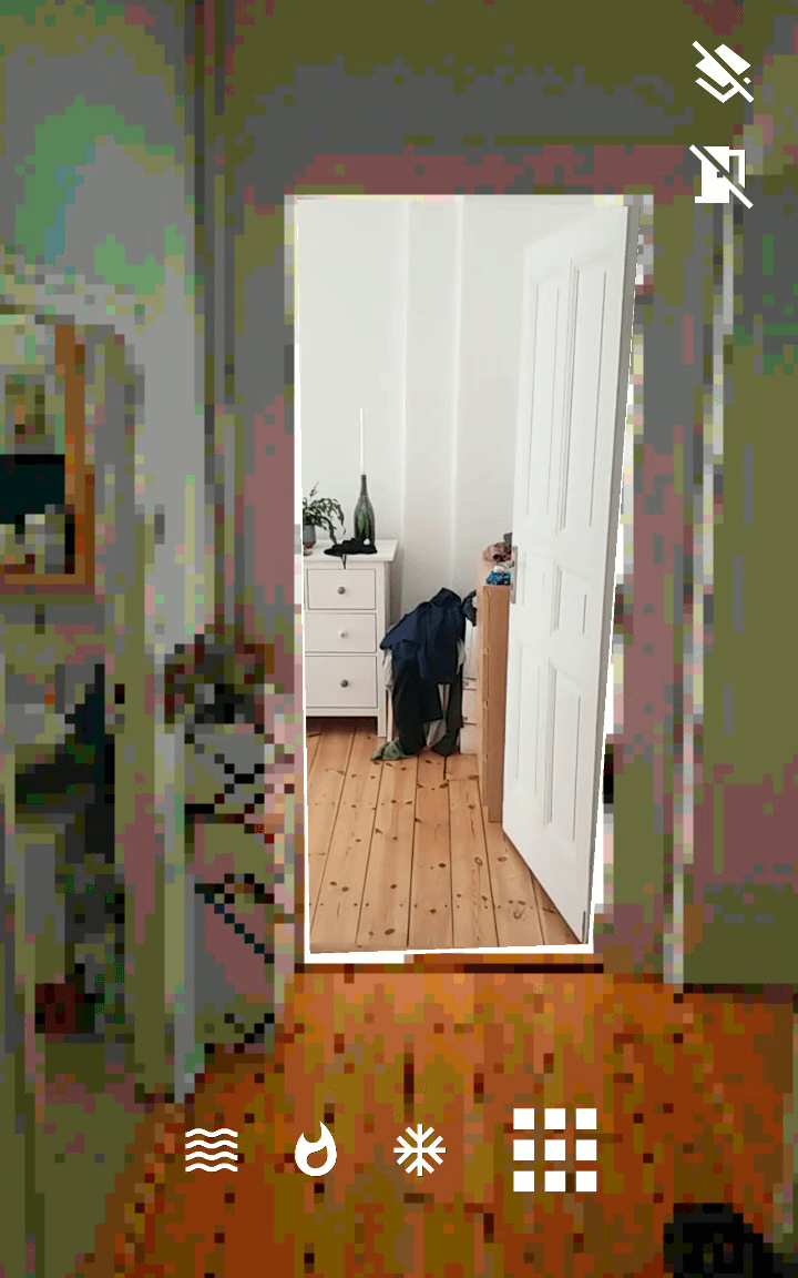 Look from the pixelated area into the real world through a portal in the doorframe.